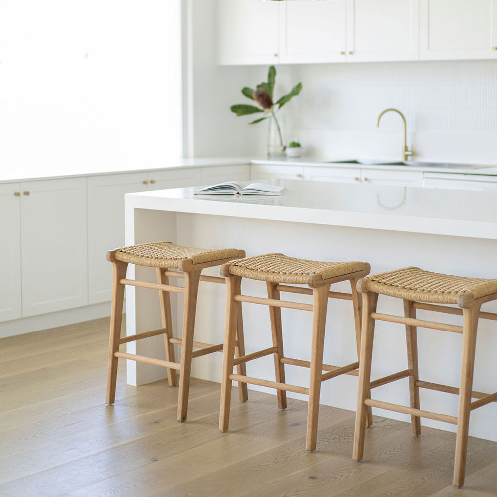 Three Zen Backless Bar Stools – Sand – Open Weave styled under a white waterfall-edge island bench in a light-filled modern kitchen.
