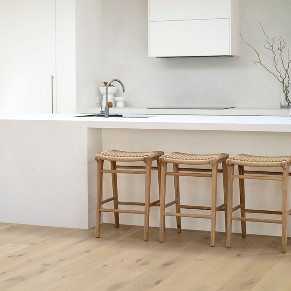 Modern kitchen interior with three Zen Backless Bar Stools – Sand – Open Weave placed at a white breakfast bar.