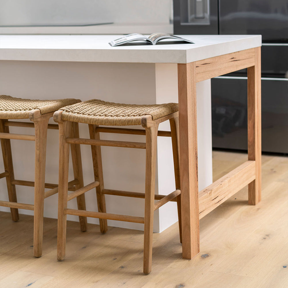 Pair of Zen Backless Bar Stools – Sand – Open Weave styled under a white stone kitchen counter in a modern setting.