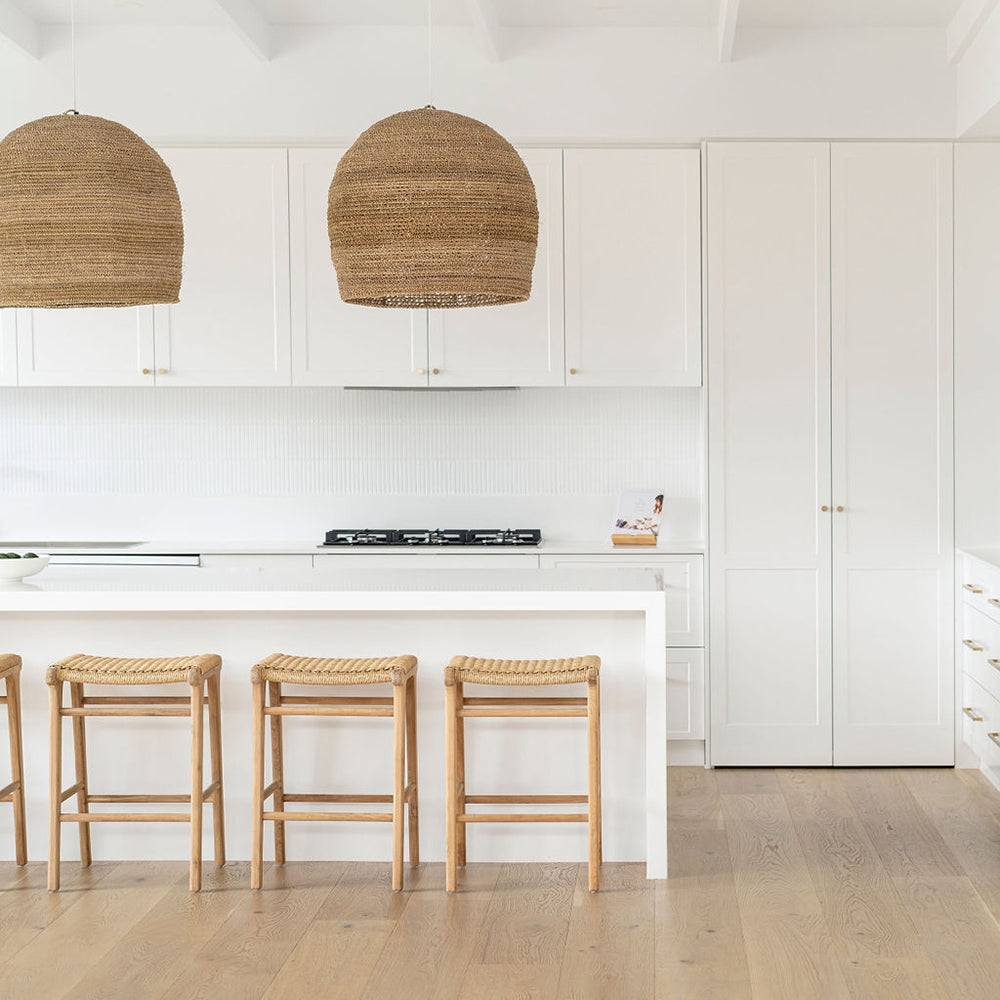Minimalist kitchen design with four Zen Backless Bar Stools – Sand – Open Weave under a crisp white bench top.