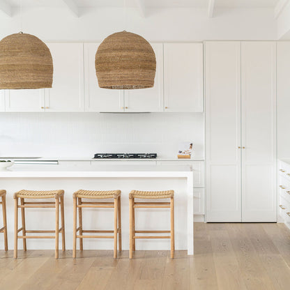 Minimalist kitchen design with four Zen Backless Bar Stools – Sand – Open Weave under a crisp white bench top.