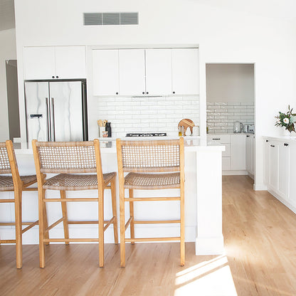 Bright modern kitchen with Zen Bar Stools – Washed Grey – Open Weave lined up at the counter for a coastal-inspired look.