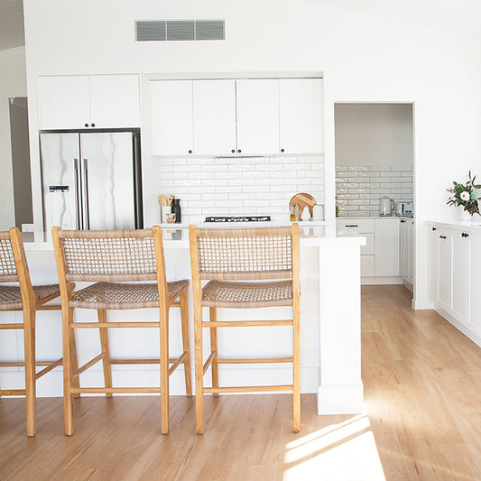 Bright modern kitchen with Zen Bar Stools – Washed Grey – Open Weave lined up at the counter for a coastal-inspired look.