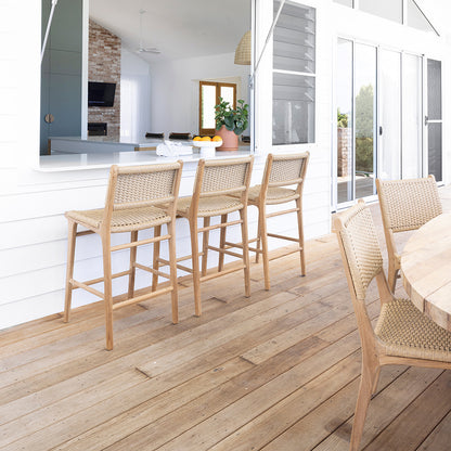Exterior breakfast bar scene with Zen Dining Chair – Sand – Close Weave paired with a white counter and large sliding windows.
