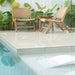 Zen Lazy Chairs in Sand styled poolside with teak side table and tropical foliage, creating a relaxed outdoor setting.
