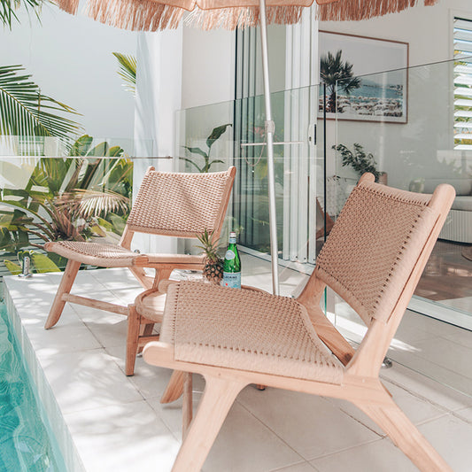 Zen Lazy Chairs in Sand with side table and tropical umbrella styled poolside on tiled patio outside glass sliding doors.