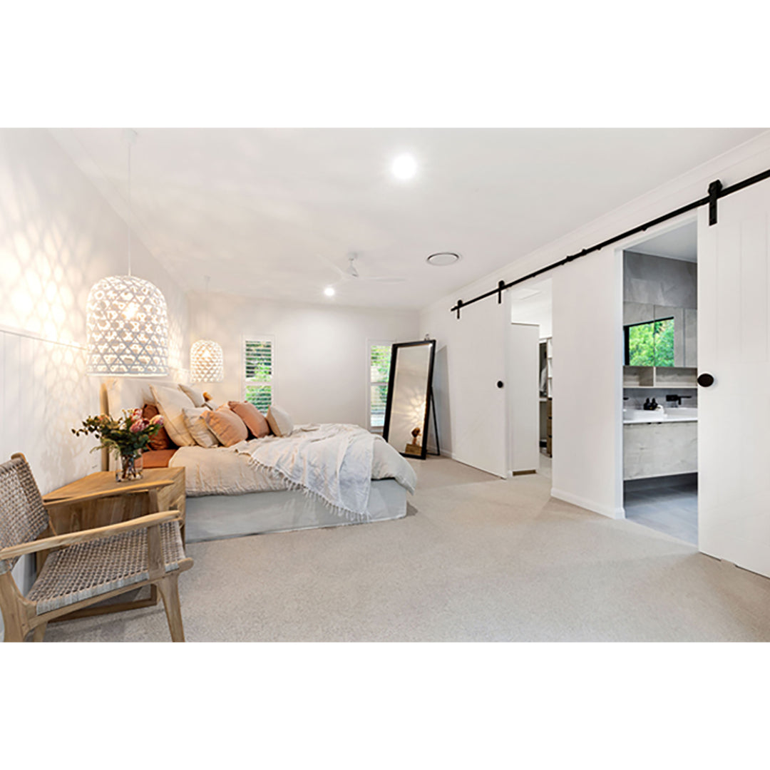 The Zen Lazy Chair – Washed Grey – Close Weave placed in a serene master bedroom with soft lighting, a neutral bedspread, and timber accents. The chair enhances the space’s relaxed, minimalist style with its curved teak frame and textural rope backrest.