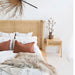 Castaway Bedside Table styled beside Castaway Bed with rattan headboard and green plant