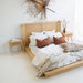 Castaway Bedside Table styled beside a rattan bedhead with cotton stems and white bedding