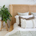 Close-up of the Castaway King Bed rattan headboard with natural timber frame and layered cushions
