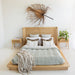 Castaway King Bed styled in a neutral bedroom with rattan headboard, natural timber frame and matching bedside tables