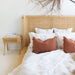 Close-up of the Castaway Queen Bed headboard with woven rattan detail and natural timber bedside table