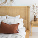 Detailed view of the Castaway Queen Bed rattan headboard with natural timber frame and bedside table