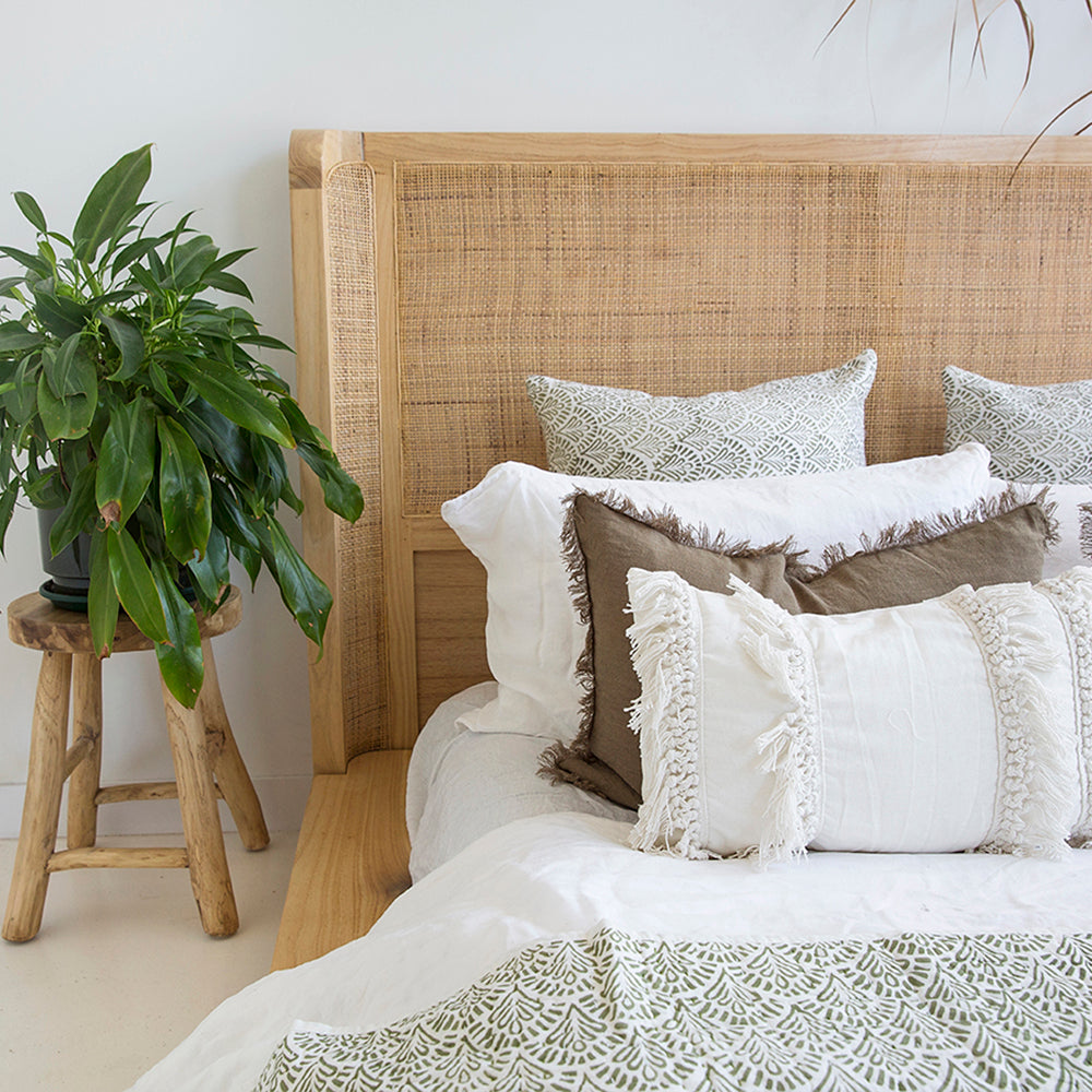 Close-up of the Castaway Queen Bed rattan headboard with natural timber frame and layered cushions