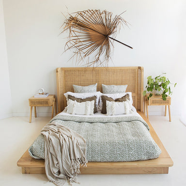 Castaway Queen Bed styled in a neutral bedroom with rattan headboard, natural timber frame and matching bedside tables