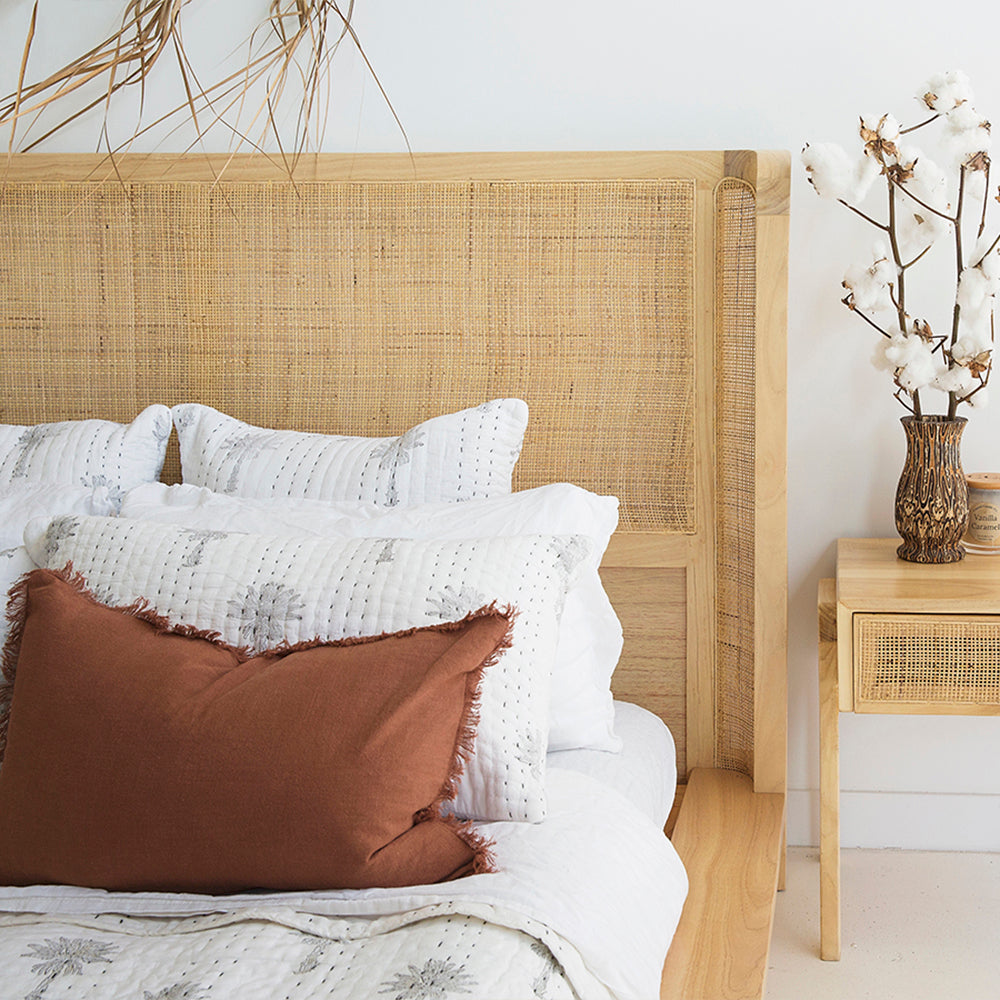 Detailed view of the Castaway Super King Bed rattan headboard with natural timber frame and bedside table