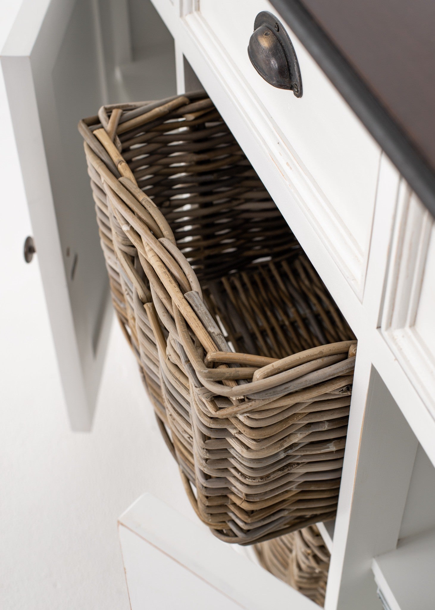 Halifax Accent Buffet with 2 baskets close-up showing removable woven rattan basket, antique black handle and white distressed sideboard finish.