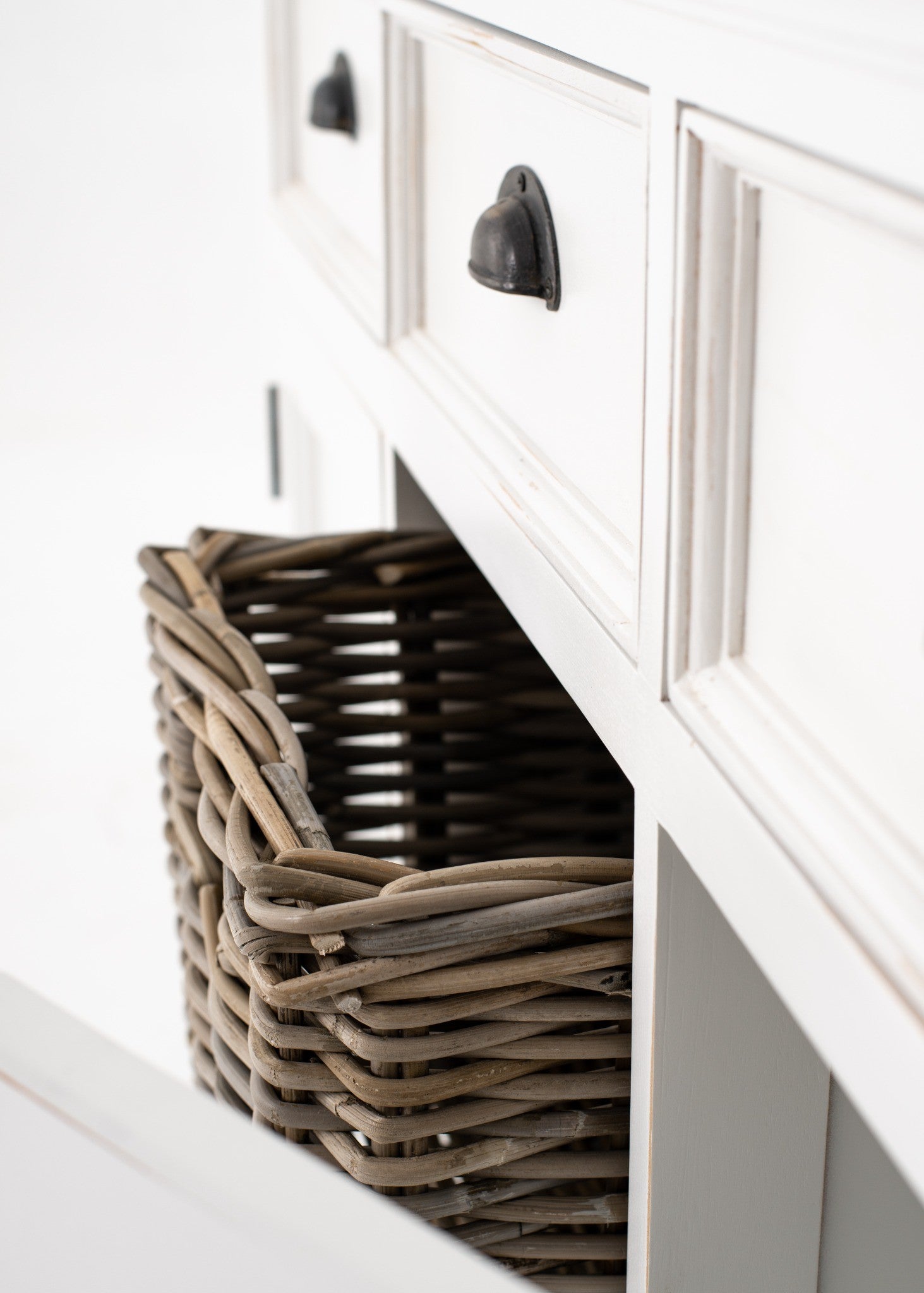 Halifax Accent Buffet with 2 baskets angled detail showing antique black drawer handle, framed white drawer front and woven rattan basket storage.