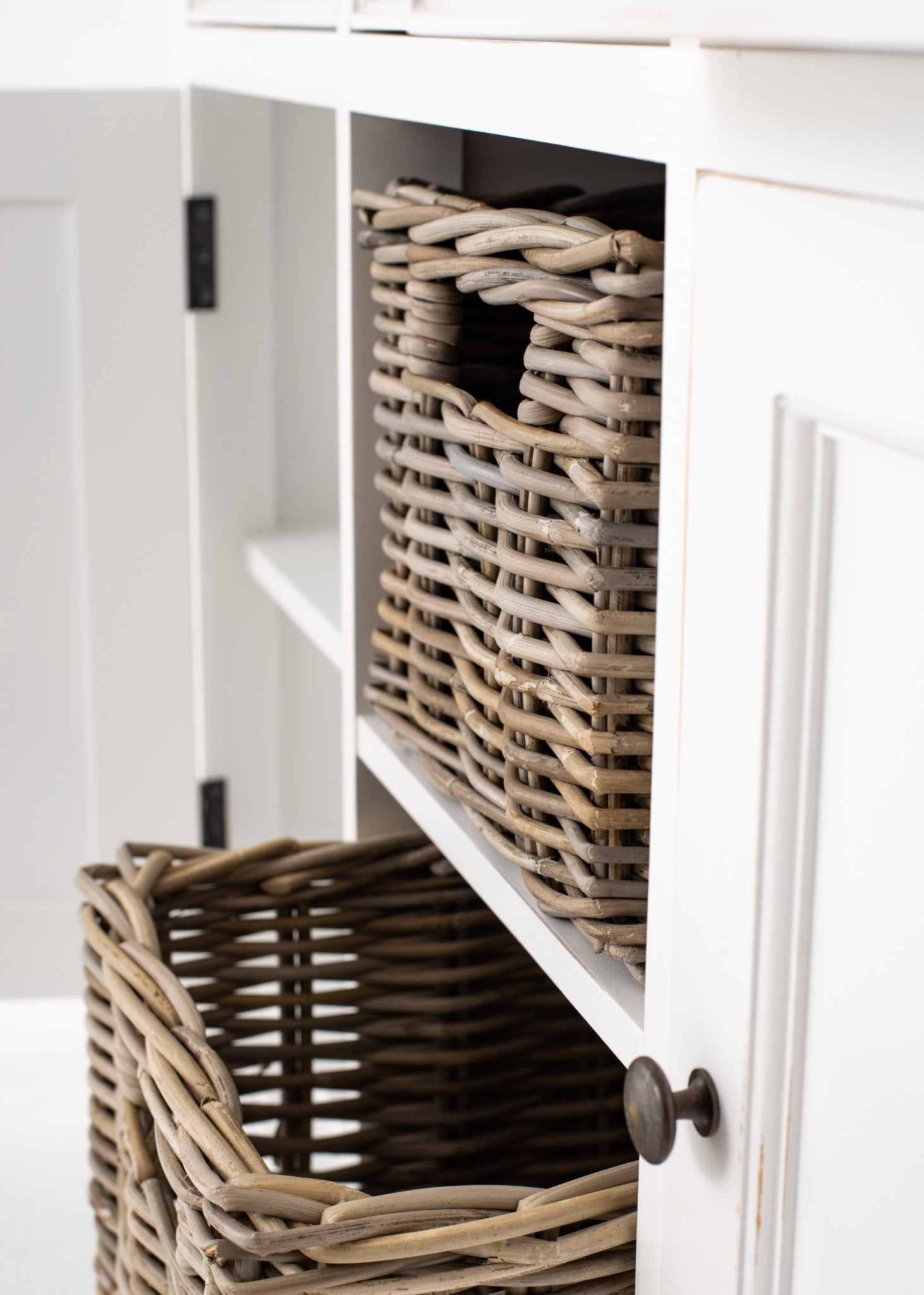 Halifax Accent Buffet with 2 baskets close-up showing woven rattan basket in centre cubby, white painted sideboard frame and open cabinet door.