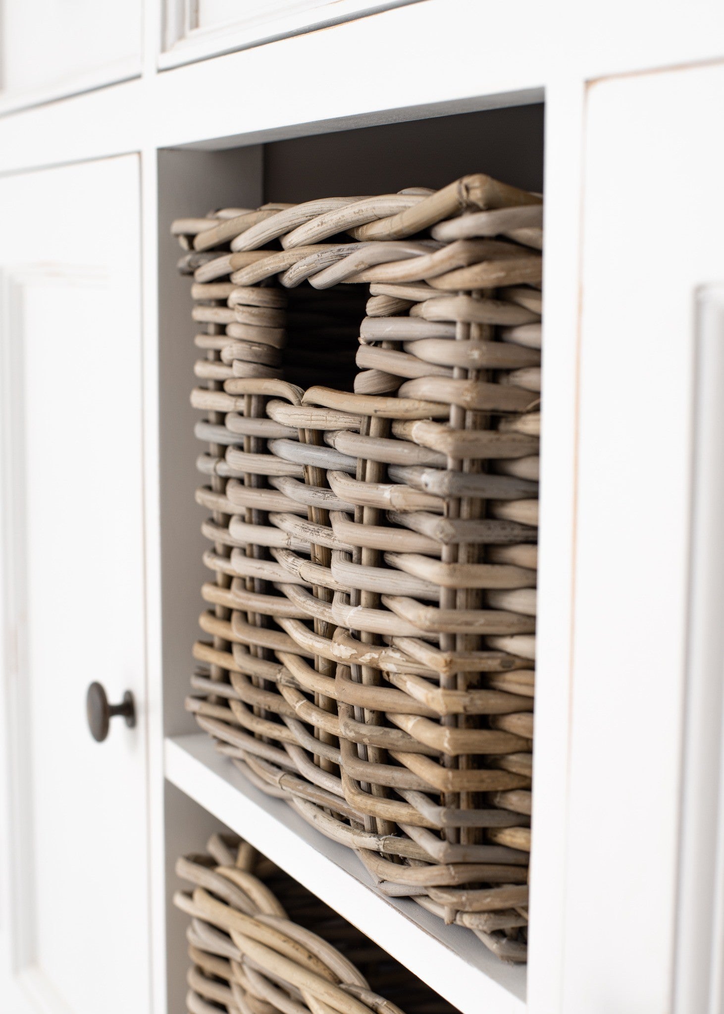 Halifax Accent Buffet with 2 baskets close-up of natural woven rattan basket in centre storage cubby with white painted sideboard surround.