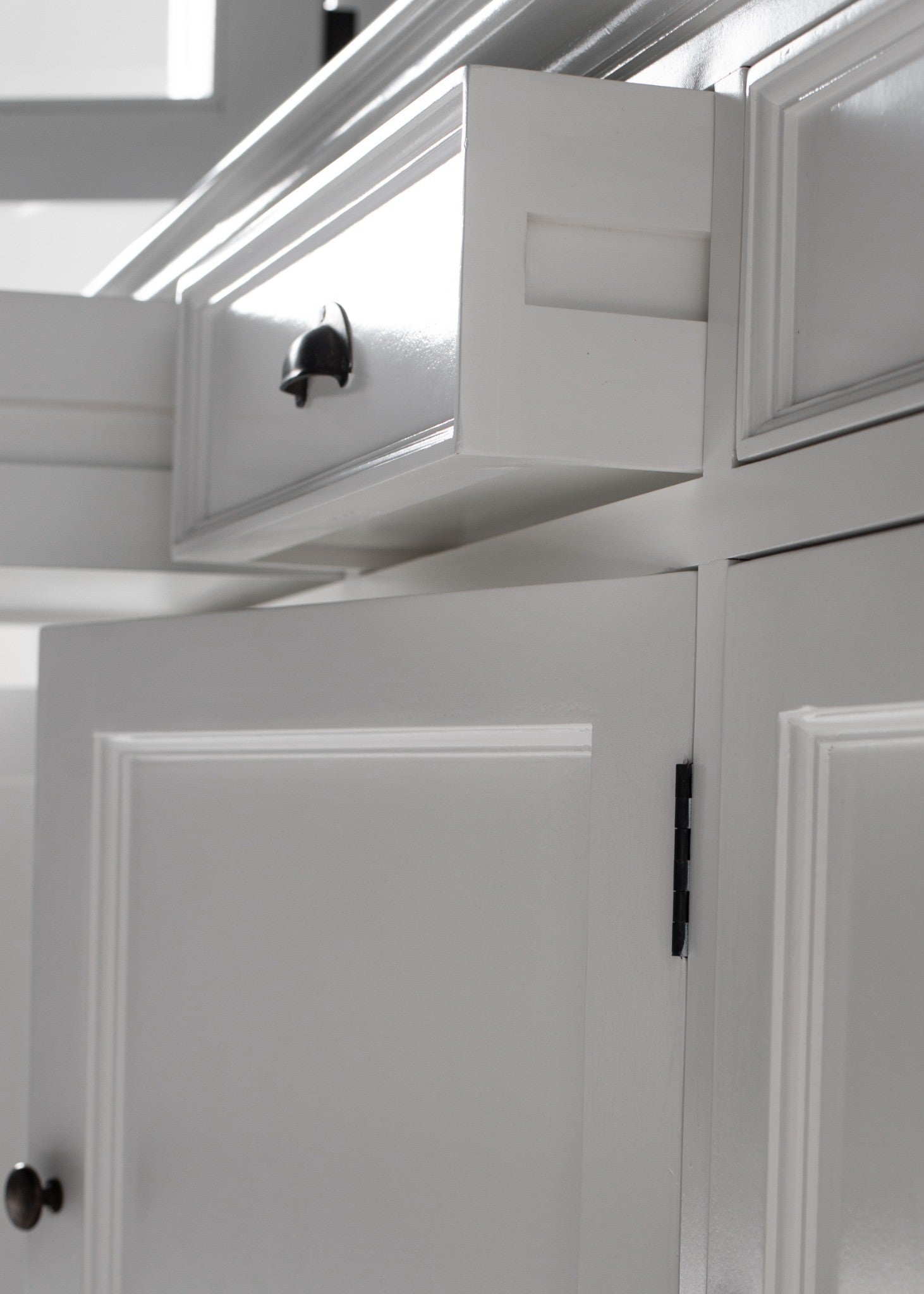 Halifax Buffet Hutch Unit with 4 Glass Doors close-up of open drawer, white painted door panels, black hinge hardware and cabinet moulding detail.