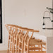 Wishbone Counter Stool in Natural Oak angled row of stools tucked under a white island bench in a bright modern kitchen.
