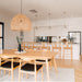Wishbone Counter Stool in Natural Oak styled at a kitchen bench behind a timber dining table in a warm modern home.