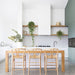Wishbone Counter Stool in Natural Oak styled at a modern white kitchen island with woven cord seats, timber legs and light coastal interiors.