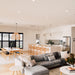 Wishbone Counter Stool in Natural Oak styled in a bright open plan home with white kitchen, timber dining setting and grey sofa.
