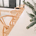 Wishbone Counter Stool in Natural Oak overhead angled view showing a row of curved timber backs and woven seats along a kitchen bench.