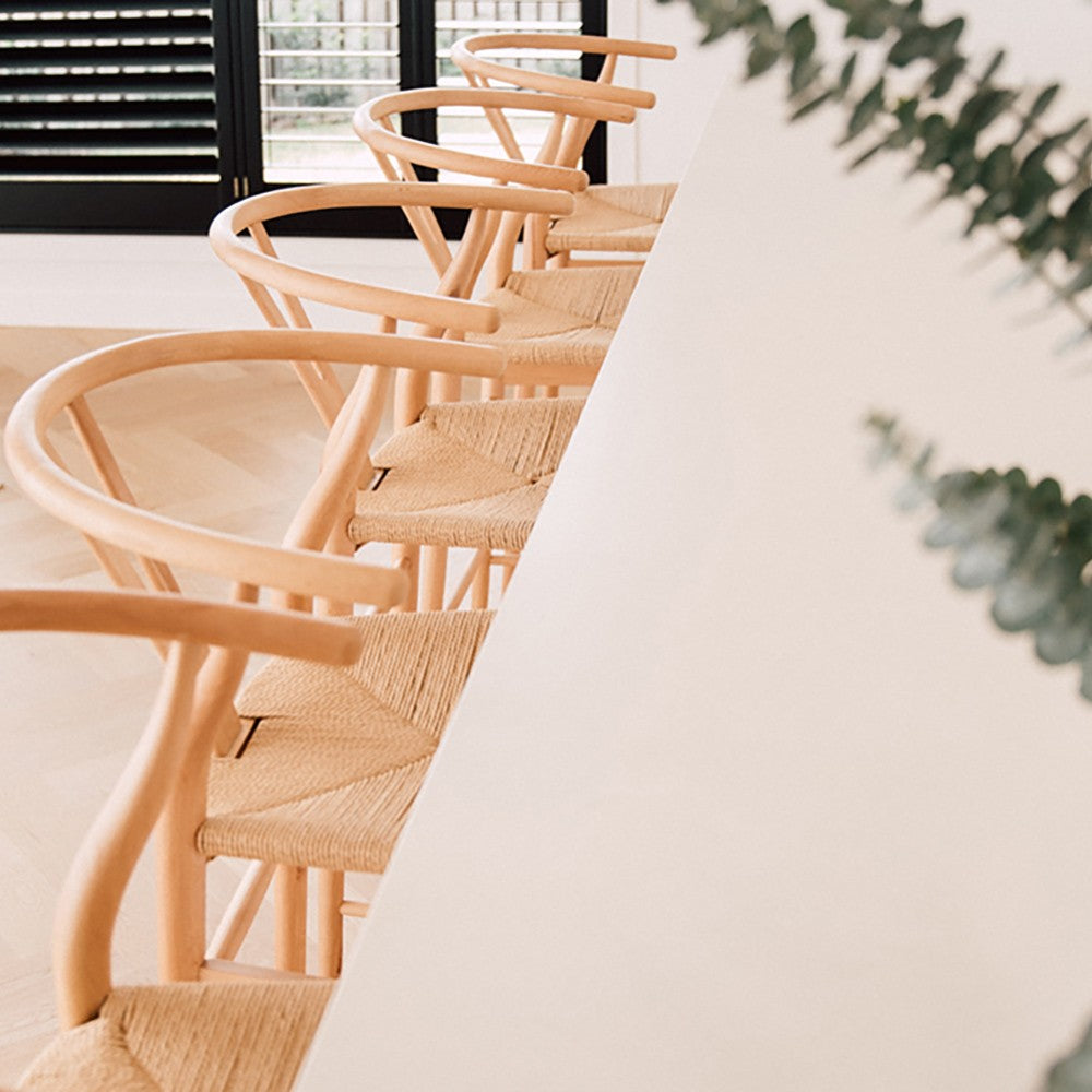 Wishbone Counter Stool in Natural Oak close up of woven cord seats and timber frames lined up along a white kitchen island.