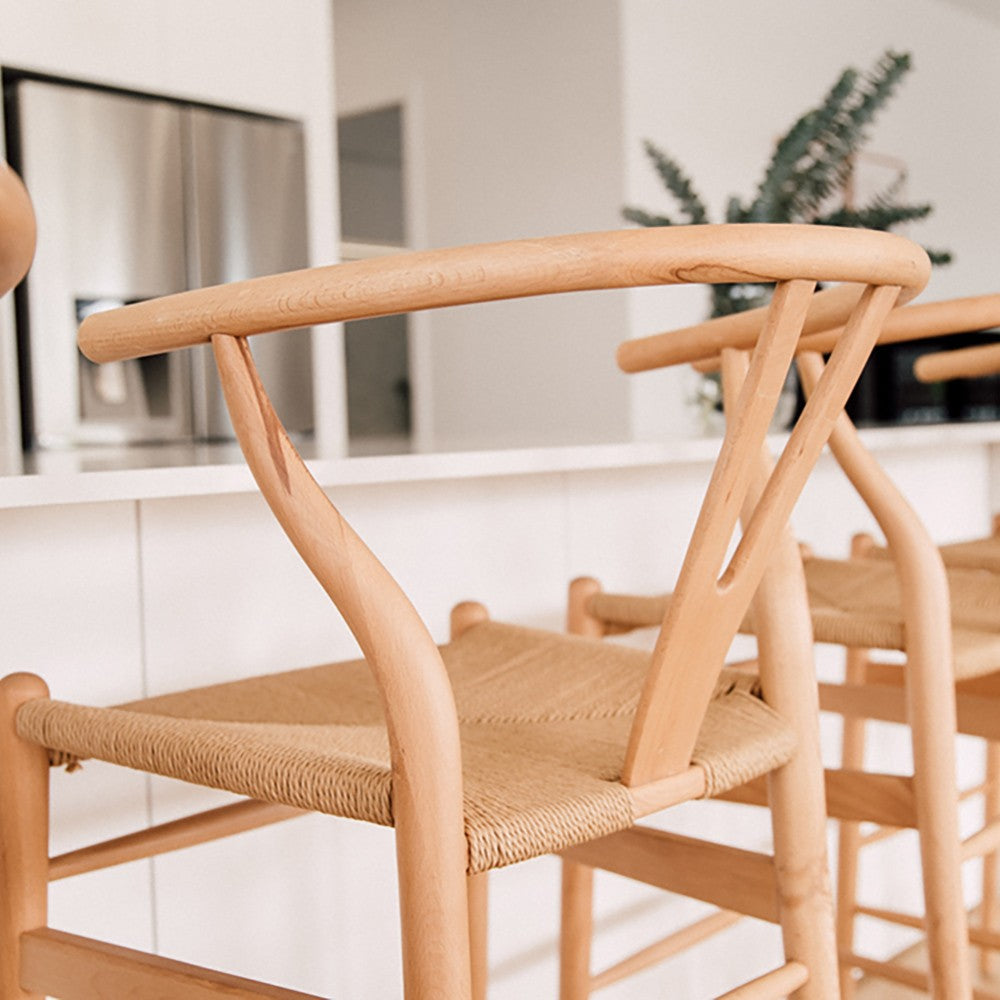 Wishbone Counter Stool in Natural Oak close up showing the rounded timber backrest, Y-shaped frame and woven cord seat at a kitchen island.