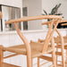 Wishbone Counter Stool in Natural Oak close up showing the rounded timber backrest, Y-shaped frame and woven cord seat at a kitchen island.