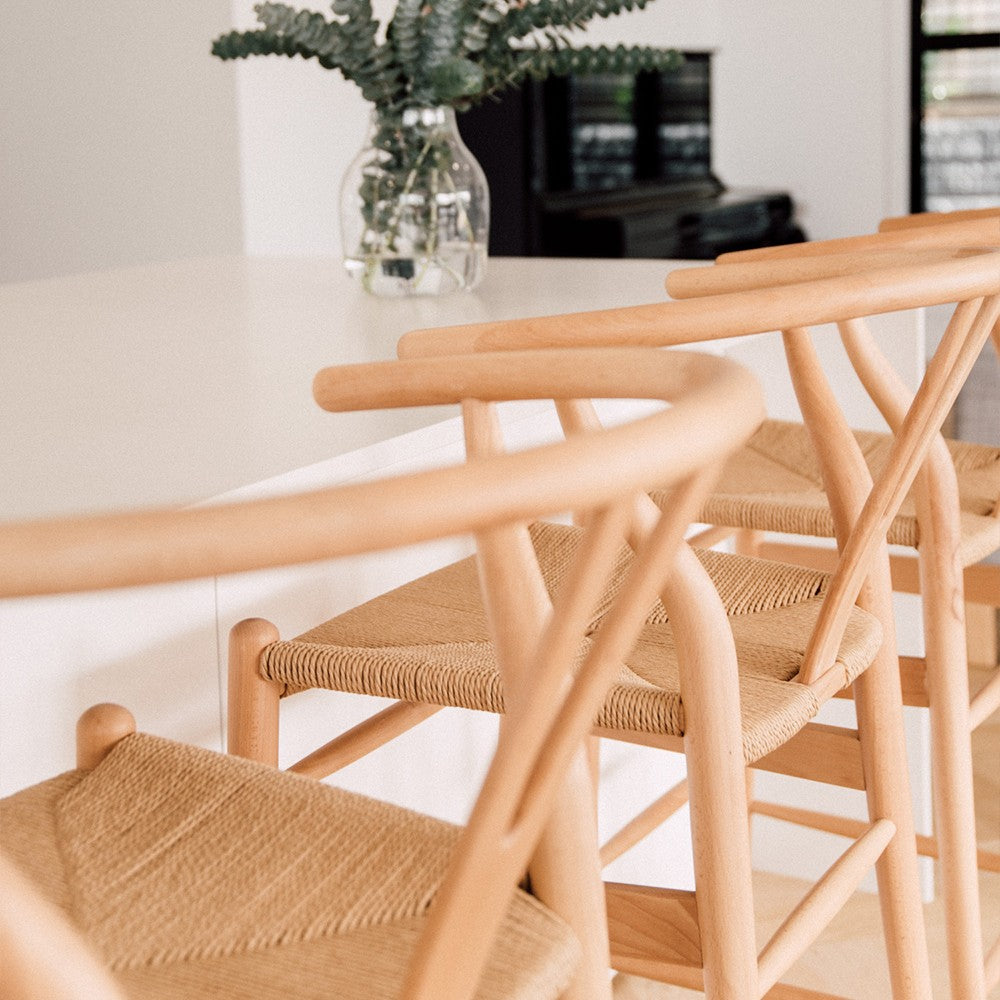 Wishbone Counter Stool in Natural Oak close up showing curved timber backrests and woven natural cord seats at a kitchen bench.